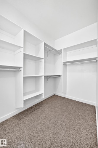 Built-in shelving, multiple hanging rods, and neutral-toned carpet flooring - 9 Tilia Place, Spruce Grove, AB 