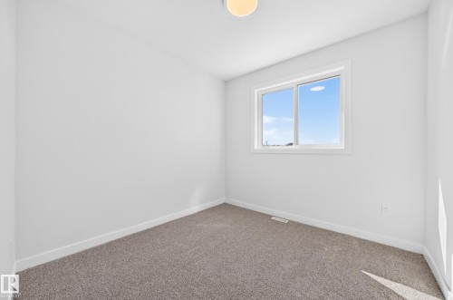 White interior walls, neutral carpet flooring, recessed lighting, and a white-framed window - 9 Tilia Place, Spruce Grove, AB 