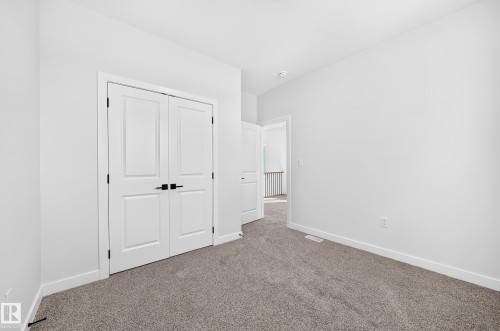 Neutral color palette with textured carpet flooring, white walls, and white trim - 9 Tilia Place, Spruce Grove, AB 