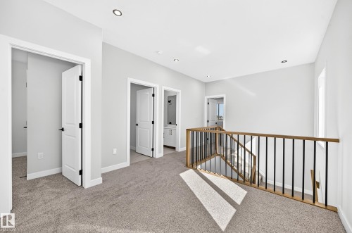 Carpeted landing featuring recessed lighting, a window, and a wood-finish and black metal railing - 9 Tilia Place, Spruce Grove, AB 