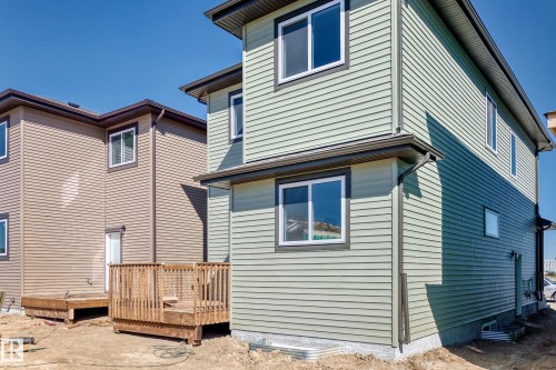 Light green horizontal siding exterior with dark trim accents, white-framed windows, and a foundation - 9 Tilia Place, Spruce Grove, AB 