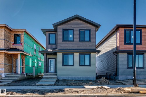 Contemporary exterior with mixed siding, dark-framed windows, a covered entry, and concrete steps - 9 Tilia Place, Spruce Grove, AB 