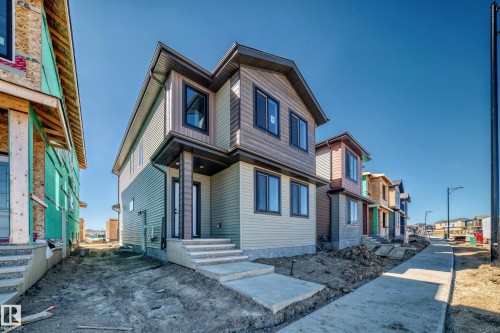 Contemporary exterior design featuring a covered entry, multi-toned siding, and dark-trimmed windows - 9 Tilia Place, Spruce Grove, AB 