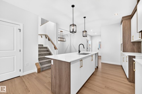 Modern kitchen island with a white countertop and integrated sink - 9 Tilia Place, Spruce Grove, AB 