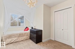 Room featuring a white-framed window with horizontal blinds, light-toned walls, and a textured ceiling - 