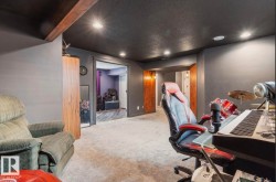Recessed lighting illuminates a spacious room featuring dark gray walls, a contrasting dark ceiling, and light-toned carpeting - 