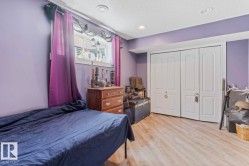 Room featuring a window with a white frame, wood-finish flooring, and white bi-fold closet doors - 