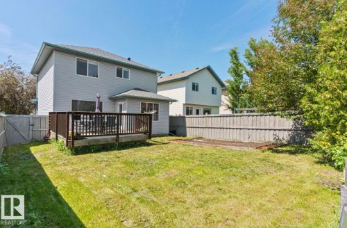 Spacious backyard featuring a substantial wood deck, privacy fencing, and a manicured lawn - 1007 Macewan Close Sw, Edmonton, AB - Outdoor
