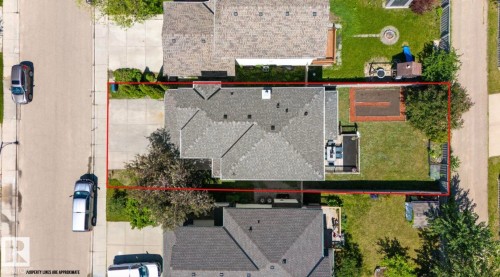 Aerial perspective showcasing the property's footprint with a gabled roofline, concrete driveway, expansive grassy backyard, and a designated garden area - 1007 Macewan Close Sw, Edmonton, AB - Outdoor