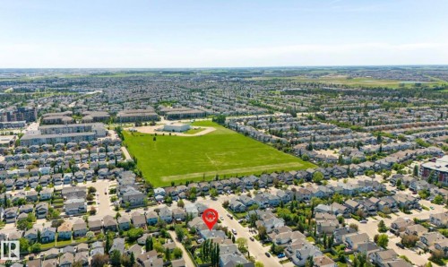 Aerial perspective showcasing a residential neighborhood with detached homes, green spaces, and community buildings - 1007 Macewan Close Sw, Edmonton, AB - Outdoor With View