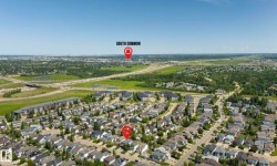 Aerial perspective showcasing a residential neighborhood with surrounding infrastructure and green spaces - 