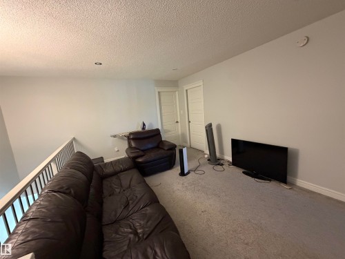 Carpeted upper level with painted walls, recessed lighting, and two panel doors - 2628 Donaghey Crescent Sw, Edmonton, AB 