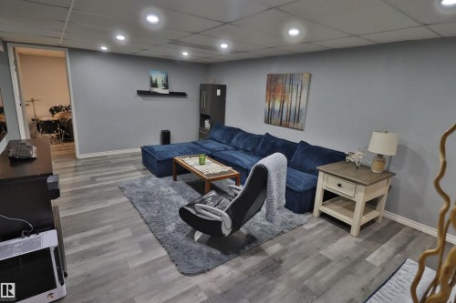 Recessed lighting illuminates the wood-finish flooring and gray wall tones - 4113 - 42 B Ave, Leduc, AB 