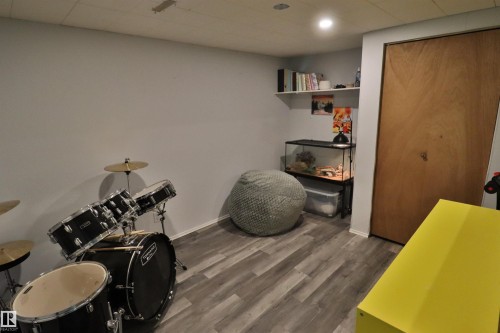 Recessed lighting illuminates the room, featuring wood-finish flooring and a wood-panel closet door - 4113 - 42 B Ave, Leduc, AB 