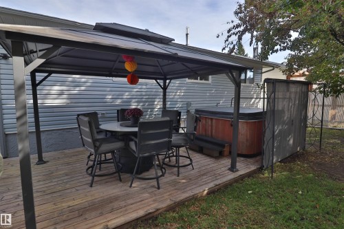 Wood-finish deck with a contemporary gazebo, featuring an integrated hot tub - 4113 - 42 B Ave, Leduc, AB 