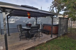 Wood-finish deck with a contemporary gazebo, featuring an integrated hot tub - 