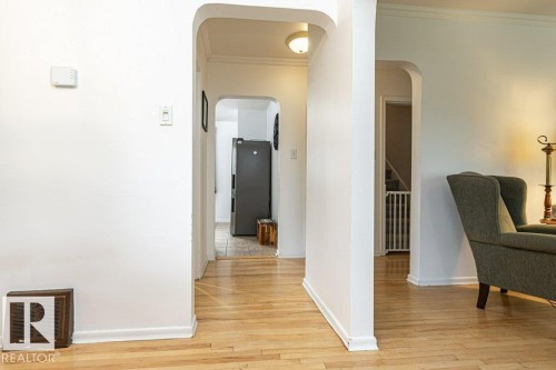 Hardwood flooring and arched doorways define this interior space - 10507 67 Avenue Nw, Edmonton, AB 