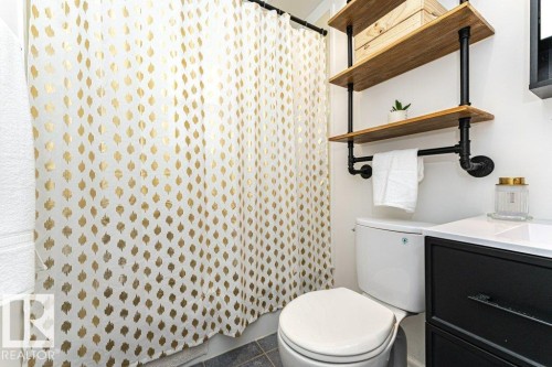 Two-tiered open shelving with wood-finish shelves and black pipe supports - 10507 67 Avenue Nw, Edmonton, AB 