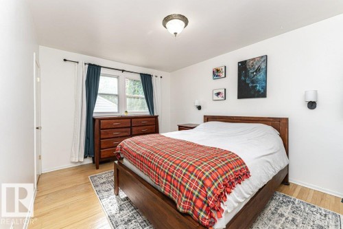 Recessed window with white trim, light wood-finish flooring, and two wall-mounted sconces - 10507 67 Avenue Nw, Edmonton, AB 