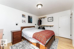 Hardwood flooring, ceiling-mounted light fixture, wall-mounted light fixtures, built-in open shelving with hanging rods - 