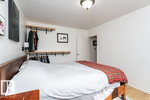 Recessed open shelving with integrated hanging rods, wall-mounted sconce, and a ceiling-mounted light fixture - 10507 67 Avenue Nw, Edmonton, AB 