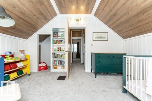Vaulted ceiling with wood-finish planks, white paneling, and light gray carpeting - 10507 67 Avenue Nw, Edmonton, AB 