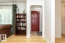Arched entryway with a paneled door, light wood-finish flooring, and crown molding - 10507 67 Avenue Nw, Edmonton, AB 
