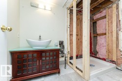 Wood-finish vanity with a vessel sink, a light fixture, and tile flooring - 