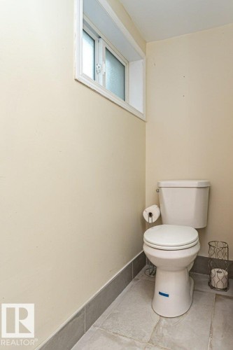 Recessed window with frosted glass, light-toned wall paint, and floor-level tile trim - 10507 67 Avenue Nw, Edmonton, AB 