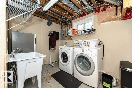 Utility sink with chrome-finish faucet, built-in shelving, and a window - 10507 67 Avenue Nw, Edmonton, AB 