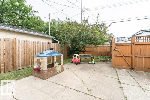 Paved patio area, wood fencing, mature trees, and a wooden gate - 10507 67 Avenue Nw, Edmonton, AB 