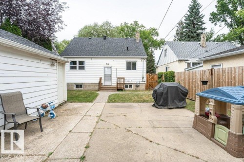 Rear exterior with white siding, a dark shingle roof, and a wood deck - 10507 67 Avenue Nw, Edmonton, AB 
