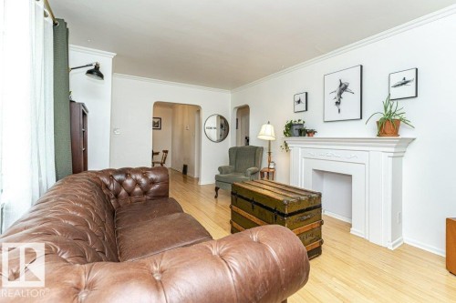 Crown molding, light wood-finish flooring, and a decorative fireplace - 10507 67 Avenue Nw, Edmonton, AB 