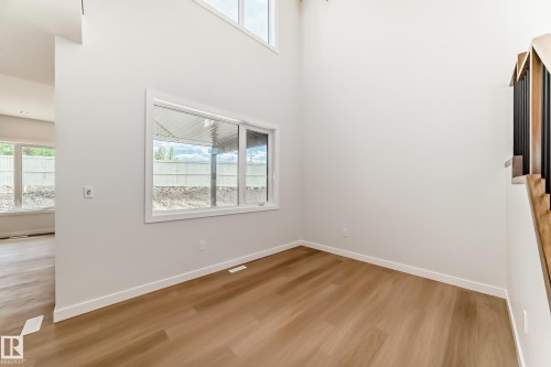 Wood-finish flooring, white walls, and a large window with white trim - 47 Meadowgrove Lane, Spruce Grove, AB 