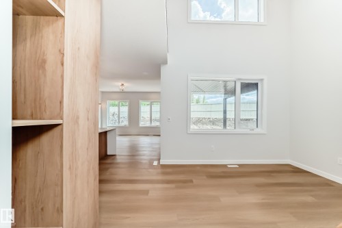 Vaulted ceiling with transom windows, wood-finish flooring, built-in shelving, and recessed lighting - 47 Meadowgrove Lane, Spruce Grove, AB 