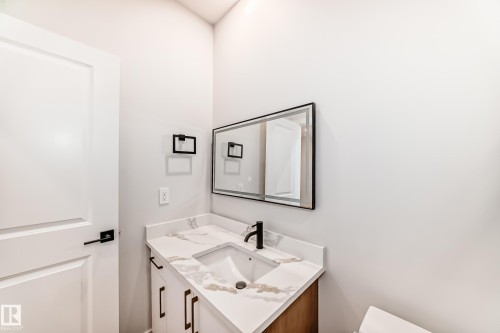 Vanity with a white countertop featuring brown veining, an undermount sink, and a black faucet - 47 Meadowgrove Lane, Spruce Grove, AB 