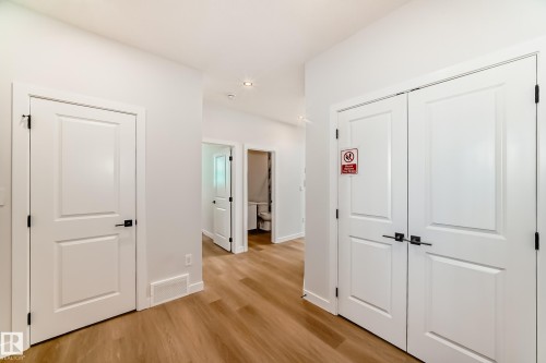 Wood-finish flooring, white paneled doors, and recessed ceiling lighting - 47 Meadowgrove Lane, Spruce Grove, AB 