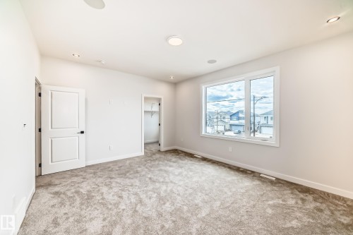Recessed lighting, light gray carpet, white interior doors, large window, and built-in closet shelving - 47 Meadowgrove Lane, Spruce Grove, AB 