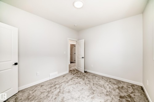 Neutral wall paint, textured carpet flooring, white trim, and a flush mount ceiling light - 47 Meadowgrove Lane, Spruce Grove, AB 