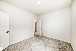 Neutral wall paint, textured carpet flooring, white trim, and a flush mount ceiling light - 