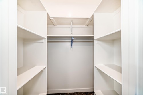 Custom closet system with multiple shelving units and integrated hanging rods - 47 Meadowgrove Lane, Spruce Grove, AB 