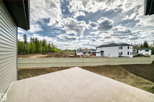 Concrete patio with a privacy fence and natural scenery - 47 Meadowgrove Lane, Spruce Grove, AB 