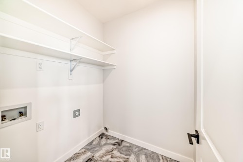 White walls, two white shelving units, a dark handle, and patterned flooring - 47 Meadowgrove Lane, Spruce Grove, AB 