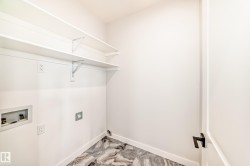 White walls, two white shelving units, a dark handle, and patterned flooring - 
