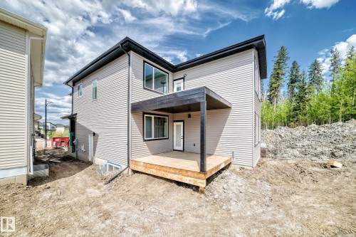 Exterior featuring light-toned horizontal siding and black-trimmed windows - 47 Meadowgrove Lane, Spruce Grove, AB 