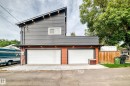 Modern two-story residence featuring a newly constructed garage with dual white panel doors, horizontal metal accents, and warm wood-finish fencing - 12045 64 Street Nw, Edmonton, AB 