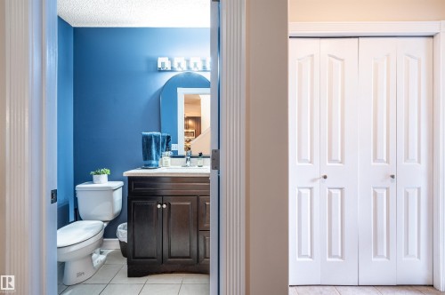 Bathroom featuring a single vanity with a dark wood-finish cabinet and a polished countertop - 38 Dubonnet Way, St. Albert, AB 