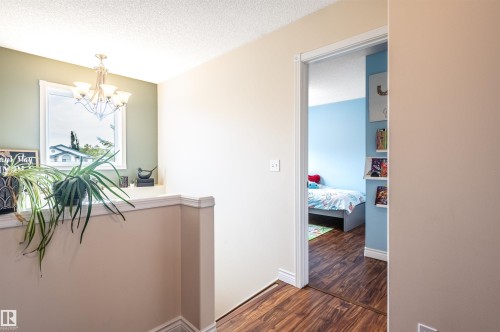 Wood-finish flooring throughout, with a recessed doorway leading to an interior room - 38 Dubonnet Way, St. Albert, AB 