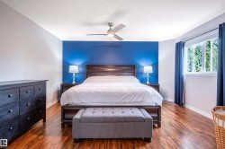 Rich wood-finish flooring, bright window with natural light, and a ceiling fan for comfort - 