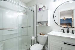 Glass-enclosed shower with white paneling - 